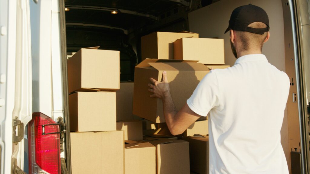 Une personne range des cartons dans un camion de déménagement.