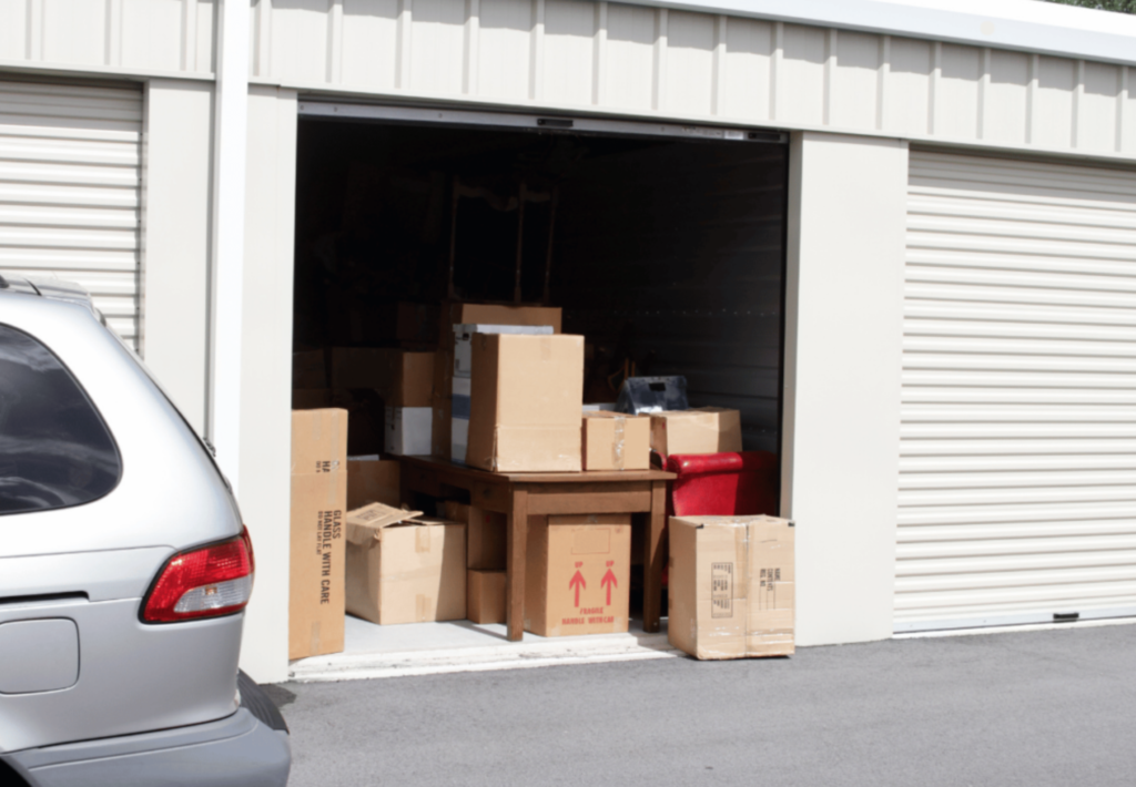 garde meuble ouvert avec store blanc où des cartons sont posés
